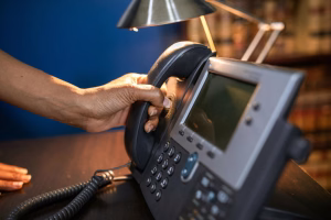 person using business phone - Fireline Broadband business telephone